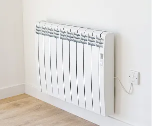 Radiateur électrique blanc fixé au mur dans un coin avec parquet et prise à Buxières-d'Aillac près de Châteauroux dans l'Indre 36