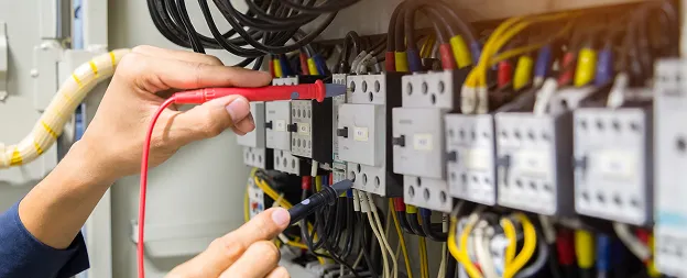 Électricien vérifiant des fils et des circuits électriques avec un multimètre à Buxières-d'Aillac près de Châteauroux dans l'Indre 36